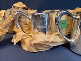 three silver pitchers sitting next to each other on a table