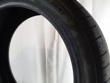a close up of a tire on a white surface with a curtain in the background
