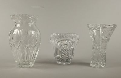 trois vases en verre posés l'un à côté de l'autre sur une table