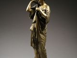 an image of a bronze statue of a woman holding a flute