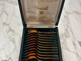 a box with six spoons in it sitting on a marble table