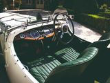 a white car with green leather seats in the driveway