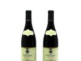 two bottles of wine sitting next to each other on a white surface