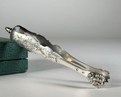 une cuillère en argent posée sur une boîte verte