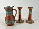 three small vases and a small pitcher sitting on a table