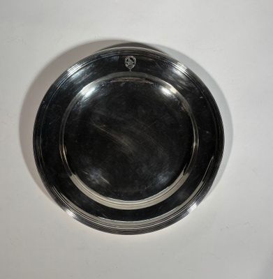 une assiette en argent posée sur une table blanche
