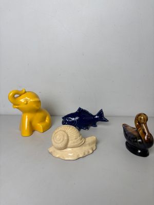 trois figurines d'animaux et un escargot posés sur une table