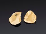 une paire de boucles d'oreilles en or sur une surface noire