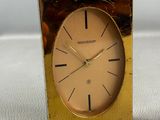 a gold clock that is sitting on a table