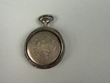 a silver pocket watch on a white surface