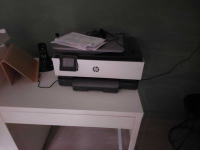 a printer sitting on top of a small white table