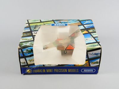 une boîte contenant un avion miniature, posée sur une table