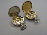 deux montres de poche dorées posées sur une table