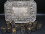 a silver tray with cups and a tray of silver cups on a table
