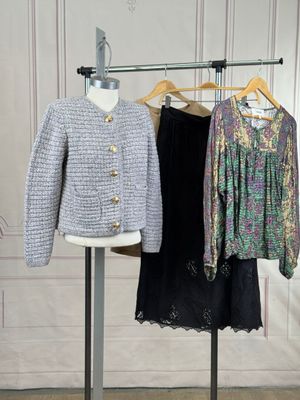 two jackets and a skirt on a stand in a room