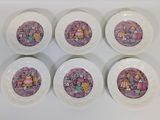 six white plates with purple designs on them sitting on a white surface