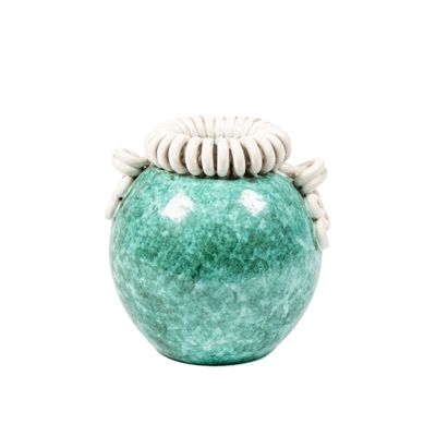 un vase vert contenant une fleur blanche