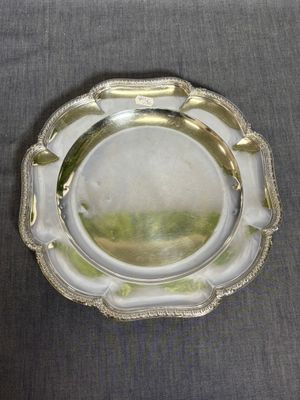 une assiette en argent ornée d'un motif décoratif sur le bord