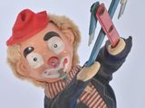 a toy of a clown with a pair of scissors in his hand