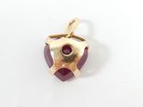 an image of a close up of a pendant with a red stone
