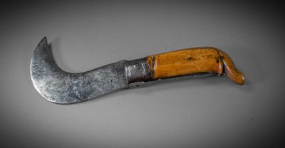 a close up of a knife with a wooden handle on a table