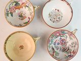 four different types of tea cups and saucers on a white surface