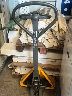 un chariot élévateur muni d'une poignée, dans un entrepôt
