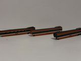 three toy trains sitting on top of a white table next to each other