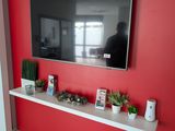 a flat screen tv mounted on a red wall in a living room