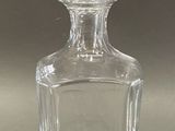 a clear glass bottle with a stopper on a table