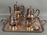 a silver tray with a silver tea set on it
