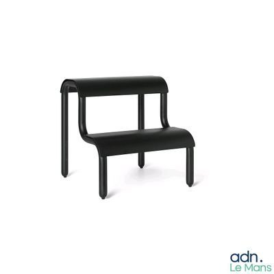 un banc noir posé sur une surface blanche