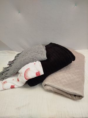 un tas de couvertures et de draps sur un lit