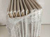 a stack of books wrapped in plastic on a table