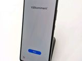 the back of a black phone with a blue button on it