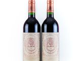 two bottles of red wine sitting next to each other on a white surface
