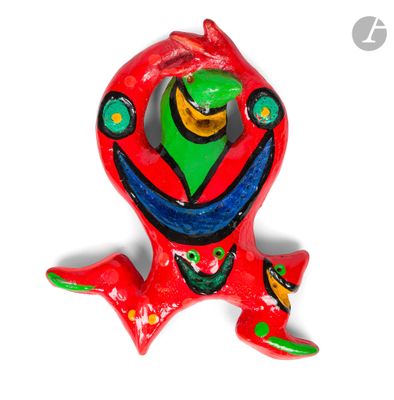 une figurine représentant une grenouille rouge au visage vert