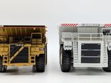 two dump trucks side by side on a white surface