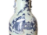 un vase bleu et blanc posé sur une surface blanche