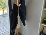 a coat rack in the corner of a room next to a window