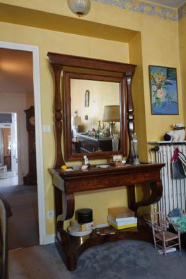 a living room with a fireplace and a mirror on the wall