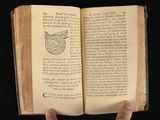 someone holding an open book with a picture of an owl on it