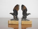 paire de serre-livres en bronze représentant des aigles, posés sur un socle en marbre, sur une table