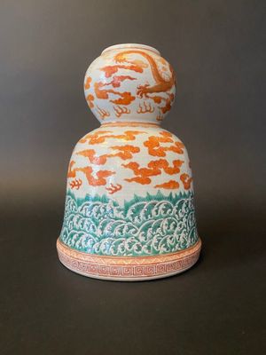 an orange and white vase sitting on top of a black table