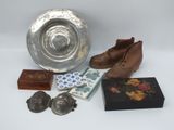 un bol en argent, une paire de chaussures, une boîte et d'autres objets posés sur une table