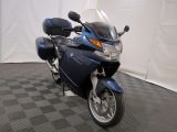 une photo d'une moto bleue garée sur un sol à damier