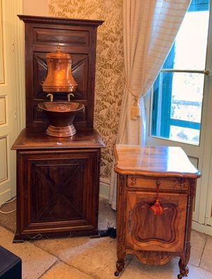 a cabinet and a table in the corner of a room