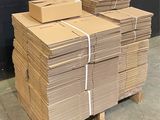 a stack of cardboard boxes on a pallet in a warehouse