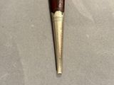 a close up of a pipe with a wooden handle on a table