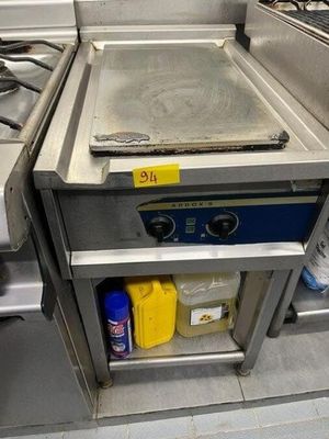 a stove with a pan on it in a commercial kitchen